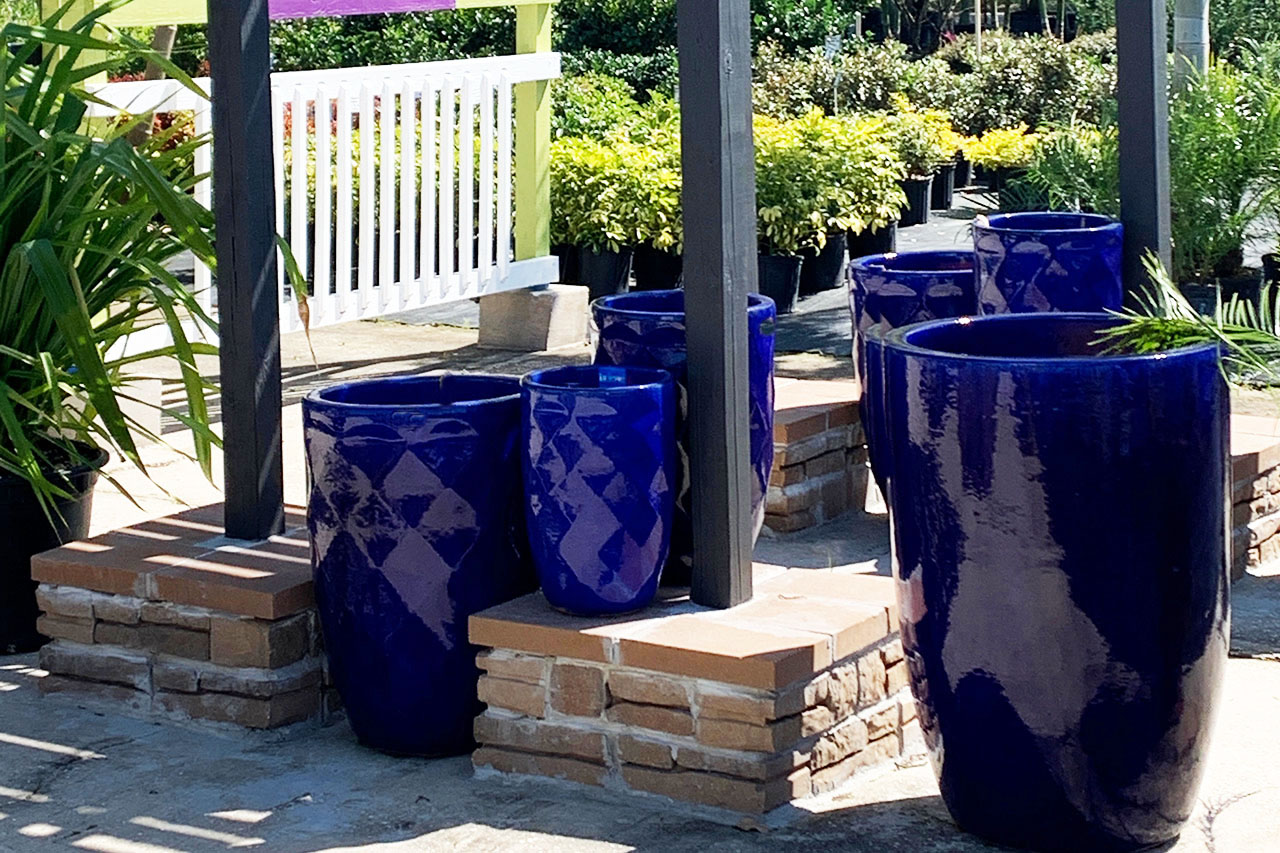 A group of blue pots sitting on top of brick.