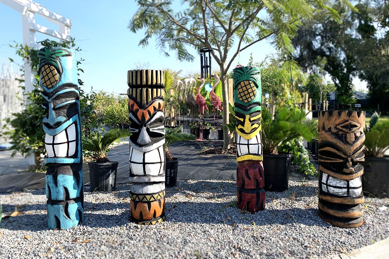 A group of tiki statues sitting in the dirt.